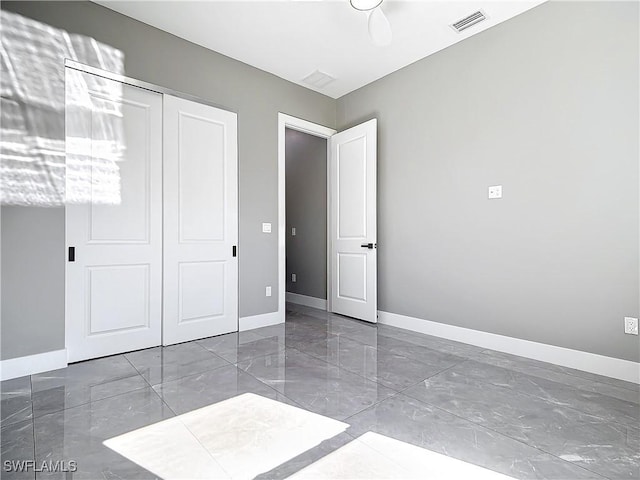 unfurnished bedroom featuring ceiling fan and a closet