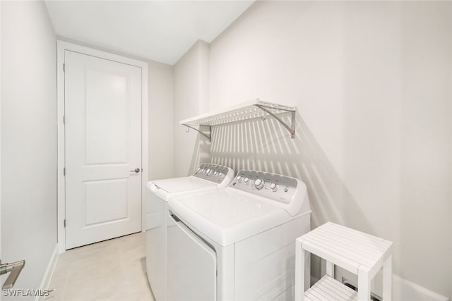 washroom with washing machine and clothes dryer and light tile patterned floors