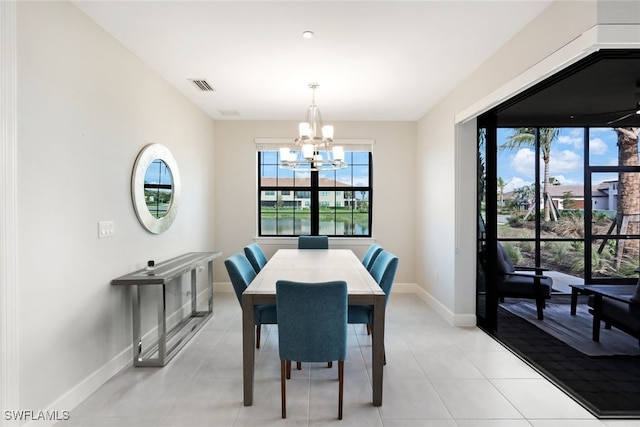 dining space with light tile patterned flooring and an inviting chandelier