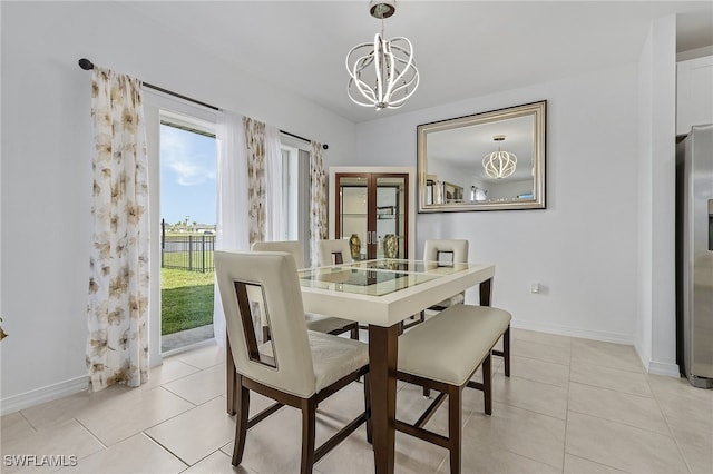 dining space with light tile patterned floors and an inviting chandelier