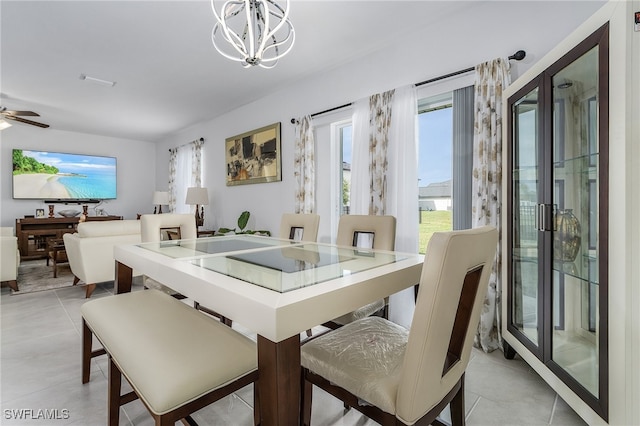 dining space with light tile patterned floors and ceiling fan with notable chandelier