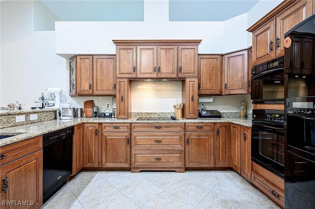 kitchen with light stone counters and black appliances