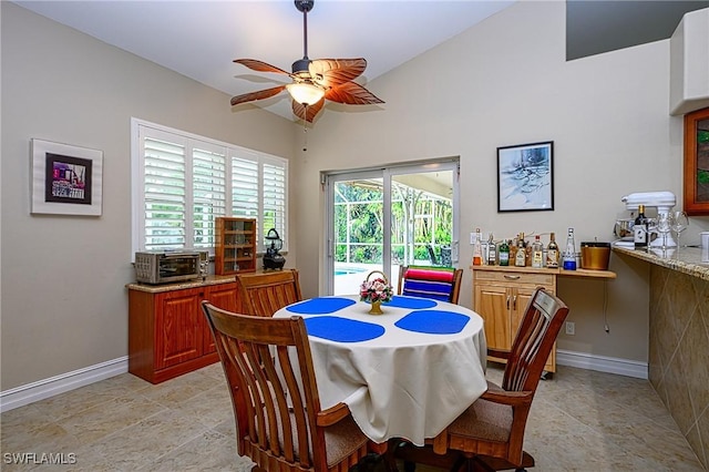 dining space with ceiling fan and vaulted ceiling