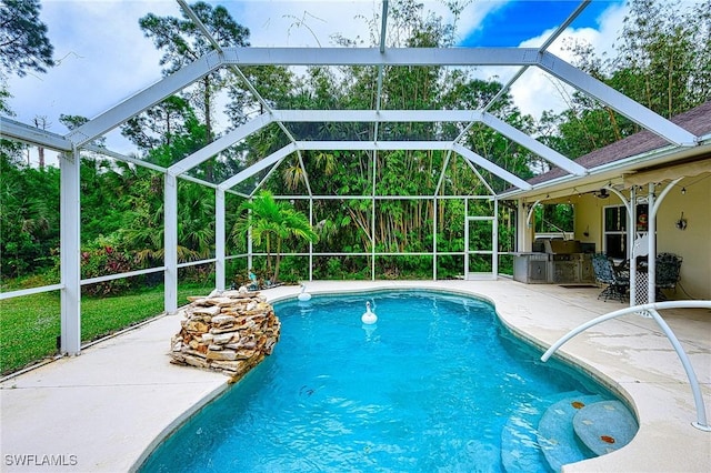 view of pool featuring an outdoor kitchen, glass enclosure, and a patio