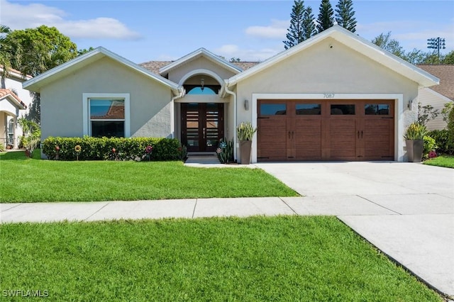 view of front of house with french doors, a front lawn, and a garage