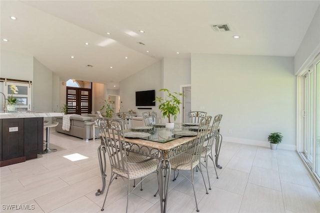 dining room with high vaulted ceiling and a healthy amount of sunlight