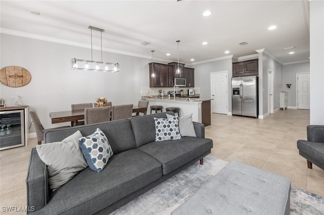 living room with wine cooler, crown molding, and light tile patterned floors