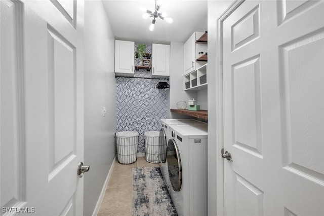 washroom featuring light tile patterned flooring, cabinets, washer and dryer, and a notable chandelier