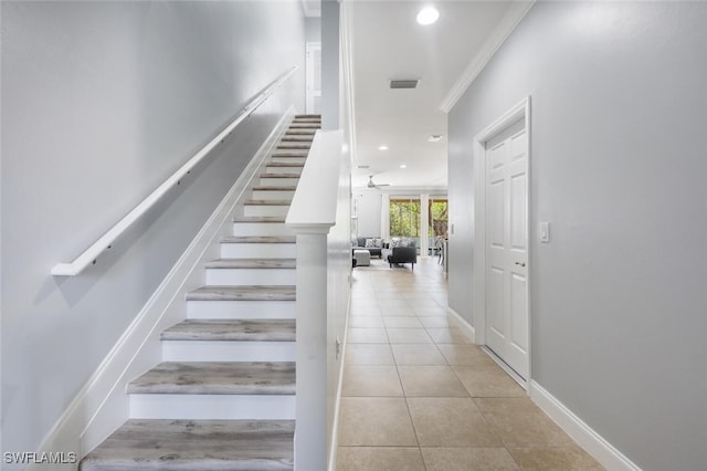 stairs featuring ceiling fan, ornamental molding, and tile patterned floors