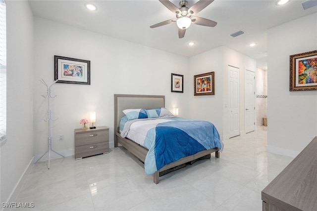 bedroom with ceiling fan and multiple closets