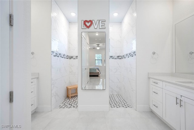 bathroom with tile patterned flooring, a tile shower, vanity, and ceiling fan