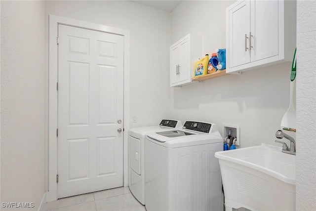 laundry area featuring washer and clothes dryer, light tile patterned floors, cabinets, and sink