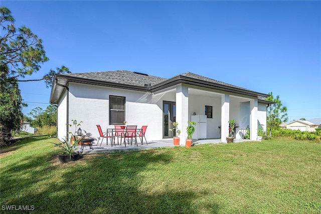 rear view of house featuring a yard and a patio