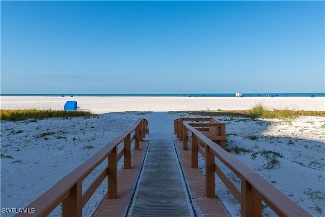 dock area featuring a water view and a beach view