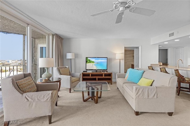 carpeted living room featuring a textured ceiling and ceiling fan