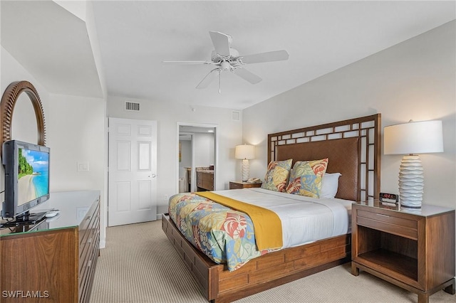 carpeted bedroom with ensuite bath and ceiling fan