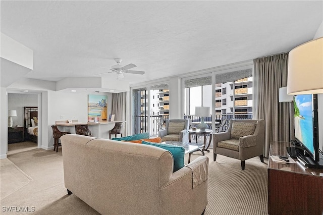 carpeted living room with a textured ceiling and ceiling fan