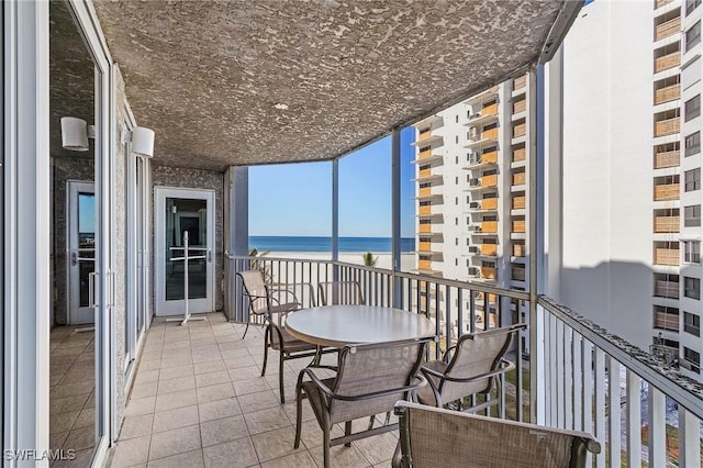 balcony with a water view and a beach view