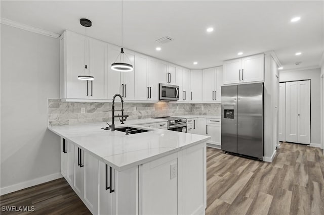 kitchen with white cabinetry, sink, decorative light fixtures, and appliances with stainless steel finishes