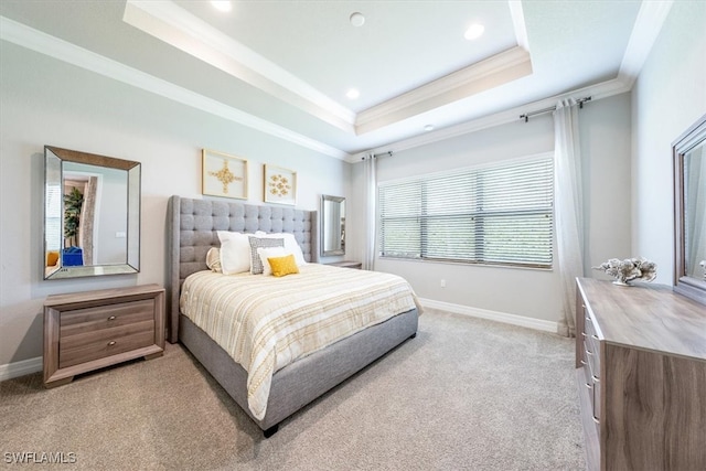 carpeted bedroom with a tray ceiling, multiple windows, and ornamental molding