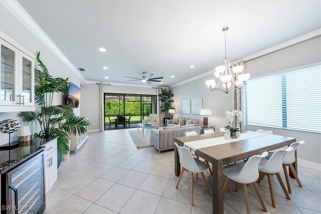 tiled dining space featuring ceiling fan with notable chandelier, crown molding, and beverage cooler