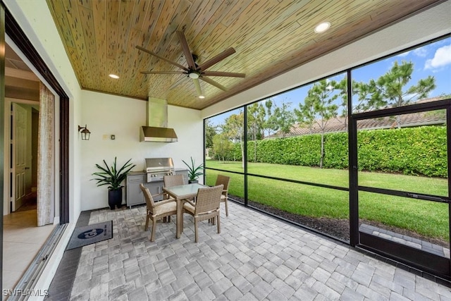 sunroom / solarium featuring ceiling fan and wood ceiling