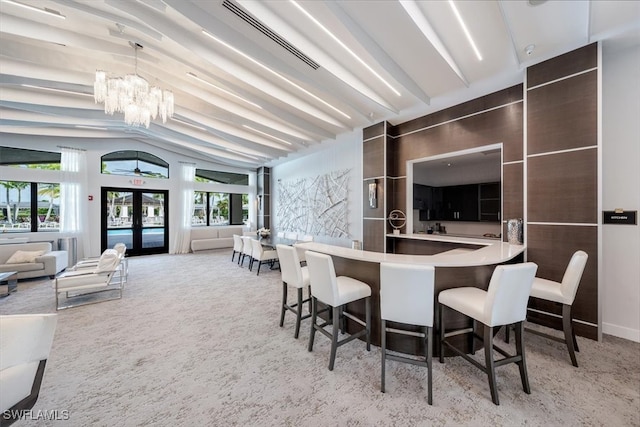 carpeted dining room with plenty of natural light, an inviting chandelier, lofted ceiling, and french doors