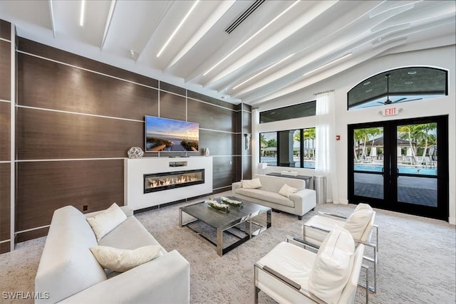 carpeted living room with french doors and vaulted ceiling