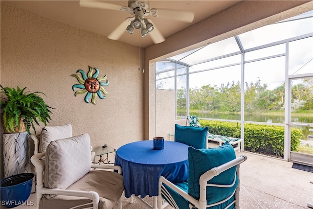 sunroom / solarium featuring ceiling fan and a water view