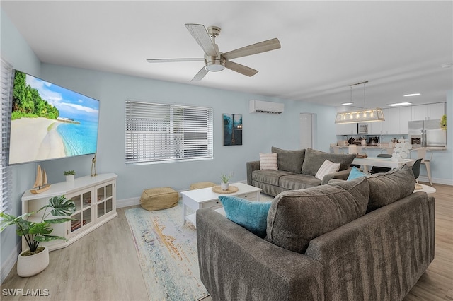 living room with ceiling fan, light hardwood / wood-style floors, and a wall mounted air conditioner