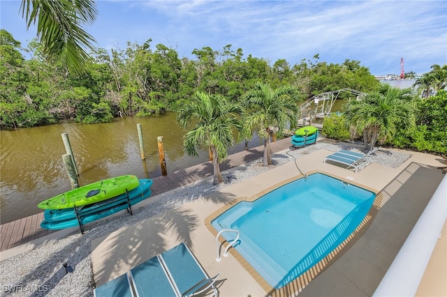 view of swimming pool featuring a water view, a patio, and a boat dock