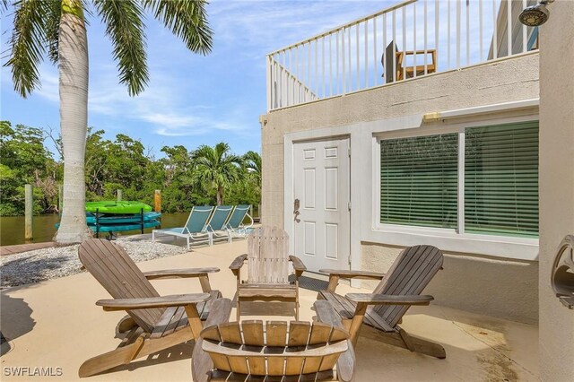 view of patio / terrace with a fire pit and a balcony