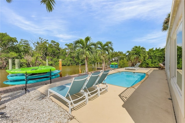 view of swimming pool with a patio area and a water view