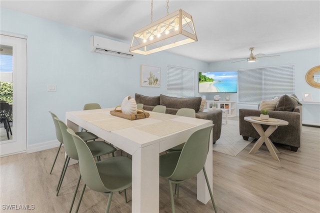 dining space with ceiling fan, light hardwood / wood-style floors, and a wall mounted air conditioner