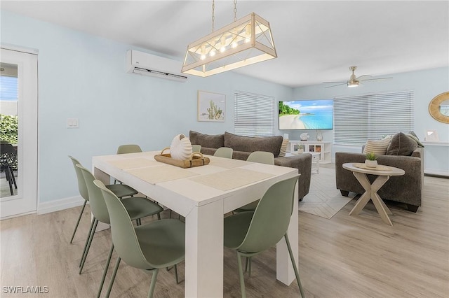 dining area with ceiling fan, light wood-type flooring, and an AC wall unit