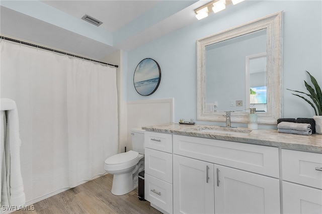 bathroom with hardwood / wood-style floors, vanity, and toilet