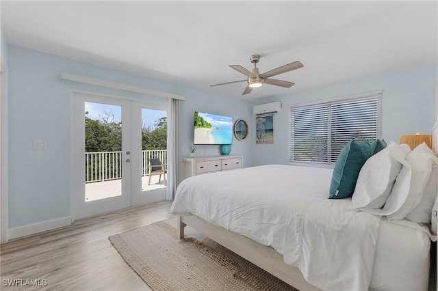 bedroom featuring ceiling fan, access to exterior, a wall mounted AC, light hardwood / wood-style floors, and french doors