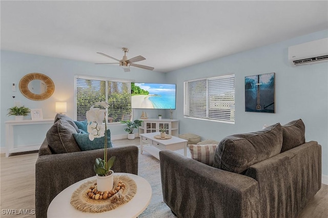 living room with ceiling fan, plenty of natural light, a wall unit AC, and light hardwood / wood-style floors