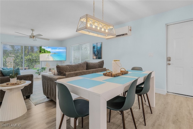 dining area featuring a wall mounted AC, light hardwood / wood-style floors, and ceiling fan