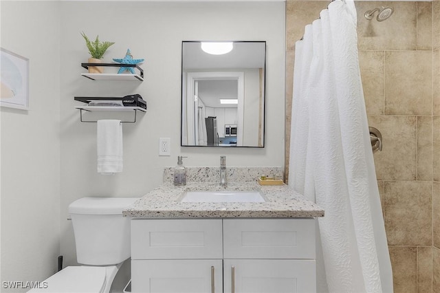 bathroom featuring vanity, curtained shower, and toilet