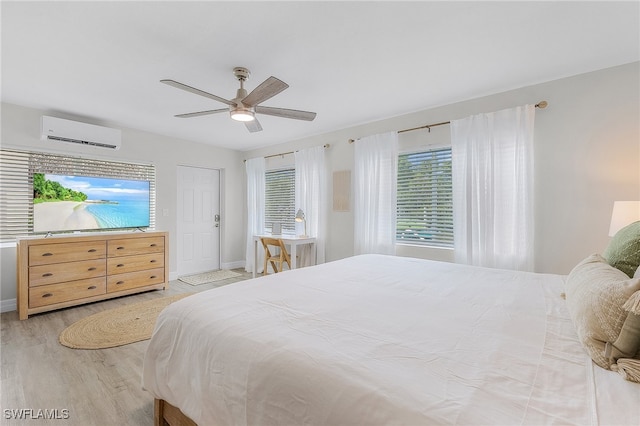 bedroom featuring a wall mounted air conditioner, light wood-type flooring, and ceiling fan