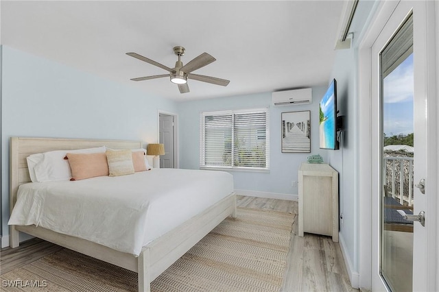 bedroom with a wall mounted air conditioner, light hardwood / wood-style flooring, and ceiling fan