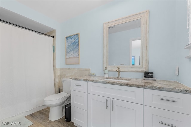 bathroom with hardwood / wood-style floors, vanity, and toilet