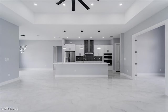 unfurnished living room featuring ceiling fan and sink