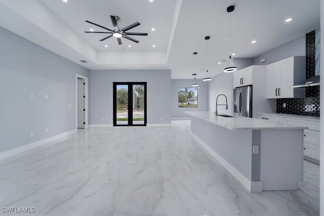 kitchen featuring white cabinets, decorative light fixtures, stainless steel fridge with ice dispenser, and a large island