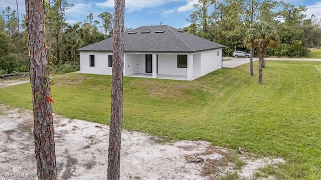 back of property with a yard and a patio