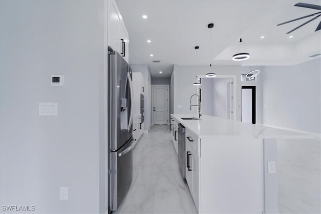 kitchen featuring sink, hanging light fixtures, an island with sink, white cabinetry, and stainless steel appliances