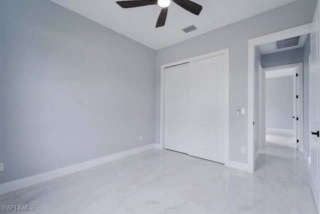 unfurnished bedroom with ceiling fan and a closet