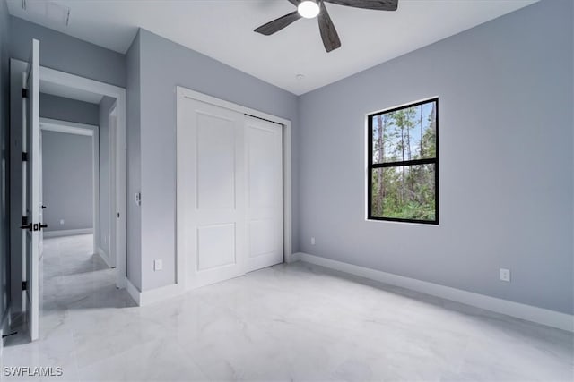 unfurnished bedroom with ceiling fan and a closet