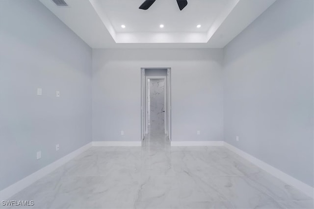 unfurnished room with a raised ceiling and ceiling fan